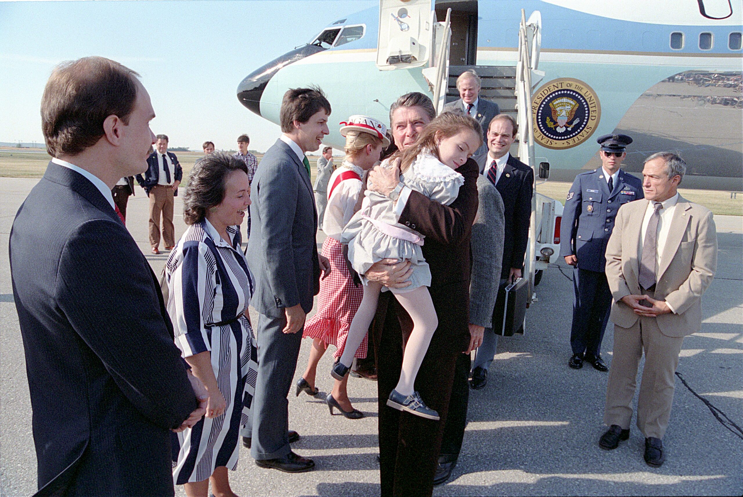President Ronald Reagan meets Katie Beckett's family and holds her on the tarmac at Cedar Rapids Municipal Airport in Iowa